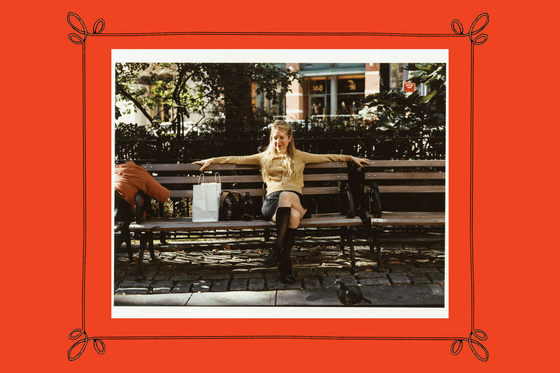 Joana Avillez relaxing on a park bench with her bags framed by a red border.