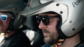 Man wearing Polestar racing helmet and sunglasses