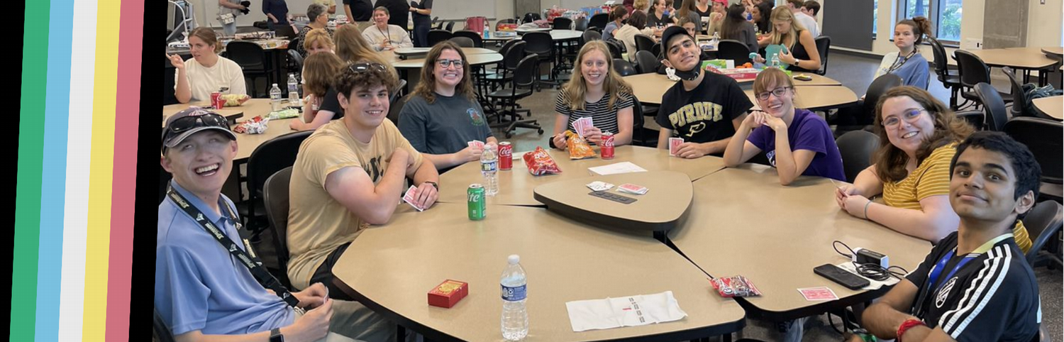 Pictured: Students in a classroom work closely with their professor, all of them on laptops.