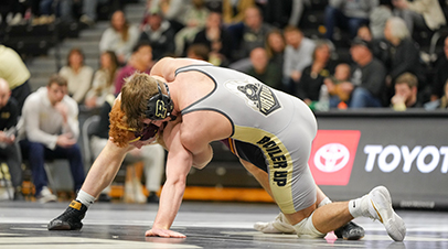 A Purdue Wrestling player competing on the mat.