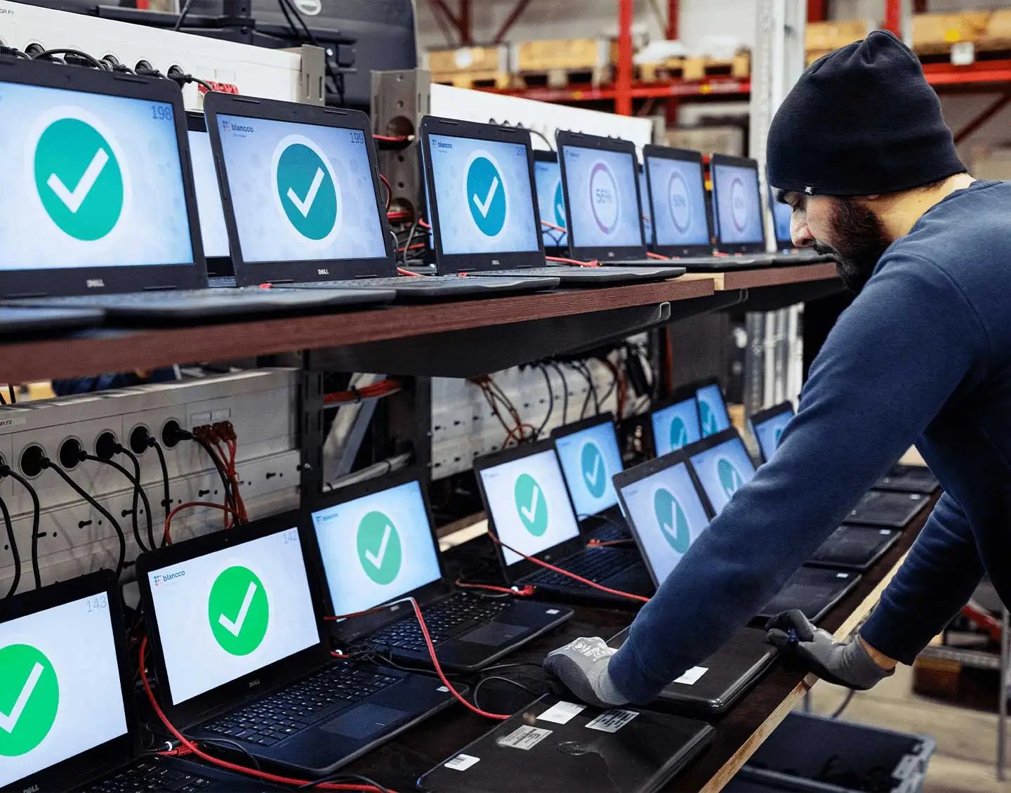 Technician in front of numerous laptops