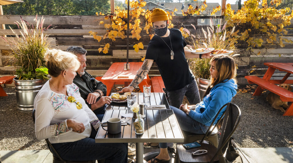 Alex Lara serves, from left, Trish, John and Jenny Purcell at Baker & Cook in Boyes Hot Springs on Wednesday, Dec. 1, 2021. (John Burgess/The Press Democrat)