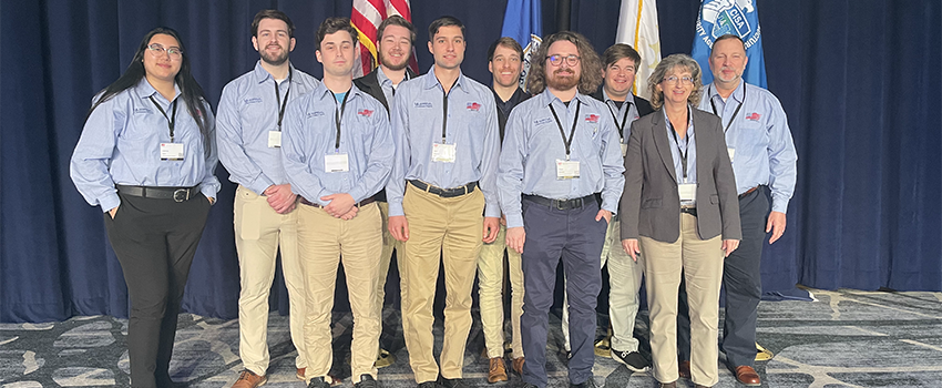 Students with professors in front of flags.