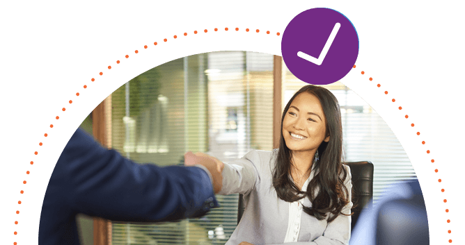 Professional, smiling business woman at an interview shaking hands with a man out of frame.