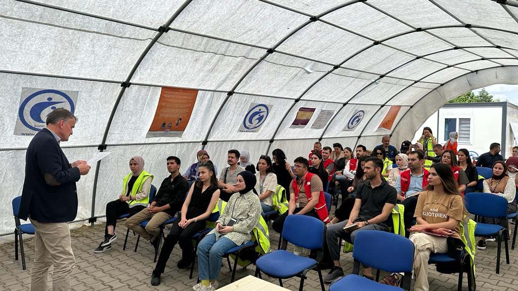 lecture attendees in a tent