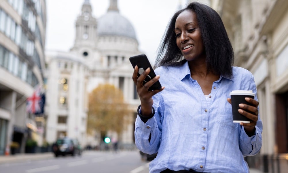 Woman walking down the street while using her phone