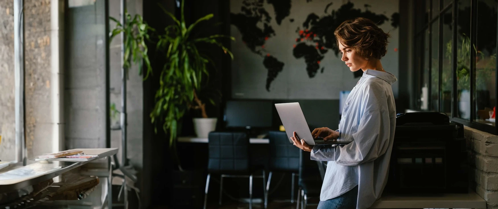 A woman working on a laptop in an office