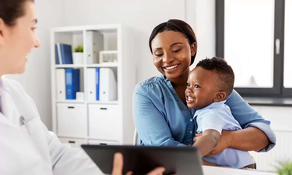 Woman holding her baby, talking to a doctor