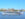 A large white cruise ship floats down the Delaware River with the Philadelphia skyline in the background.