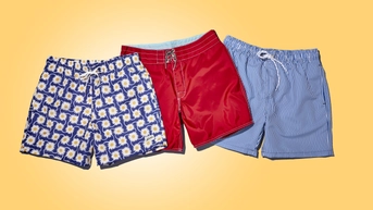 Blue and daisy print swim trunks, bright red swim trunks, and blue and white vertical stripe swim trunks on a golden yellow background. 